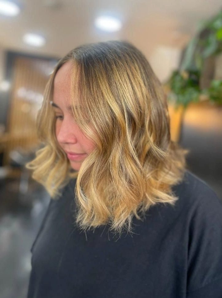 Golden face-framing highlights on a wavy lob